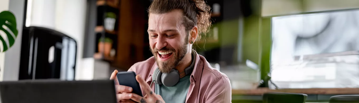 Man on phone at desk looking happy