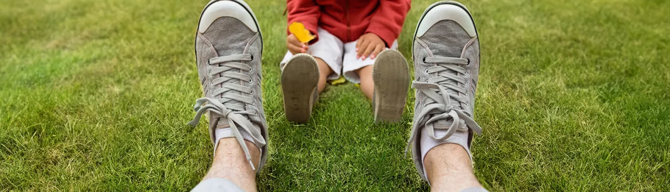dad sitting in the grass with his child 