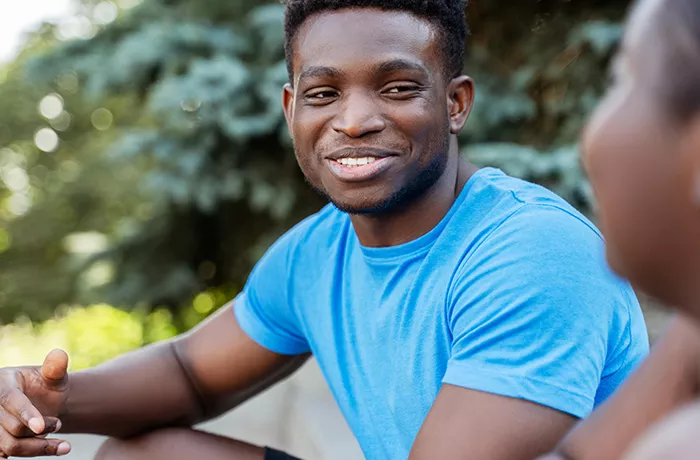 Black man in blue shirt smiling
