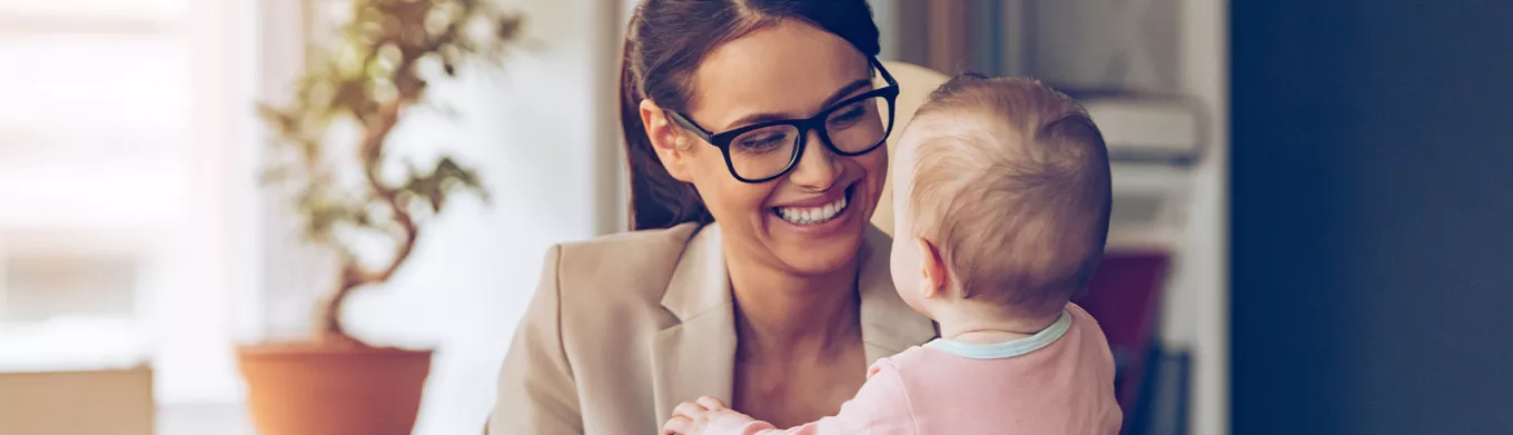 Woman holding a baby while working 