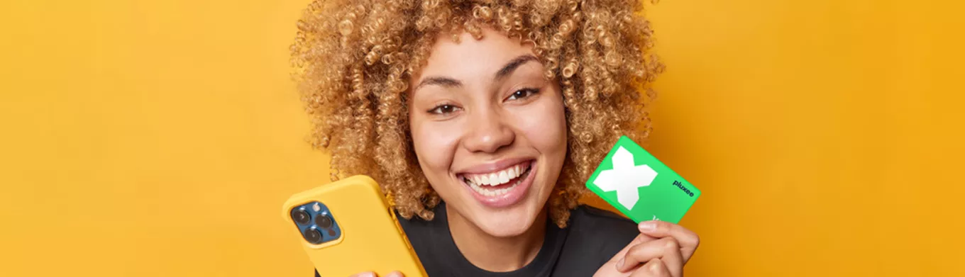 lady smiling and holding her Pluxee Card 