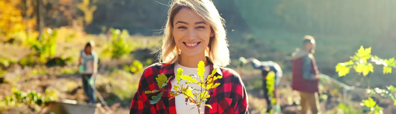 woman in a field holding a plant 