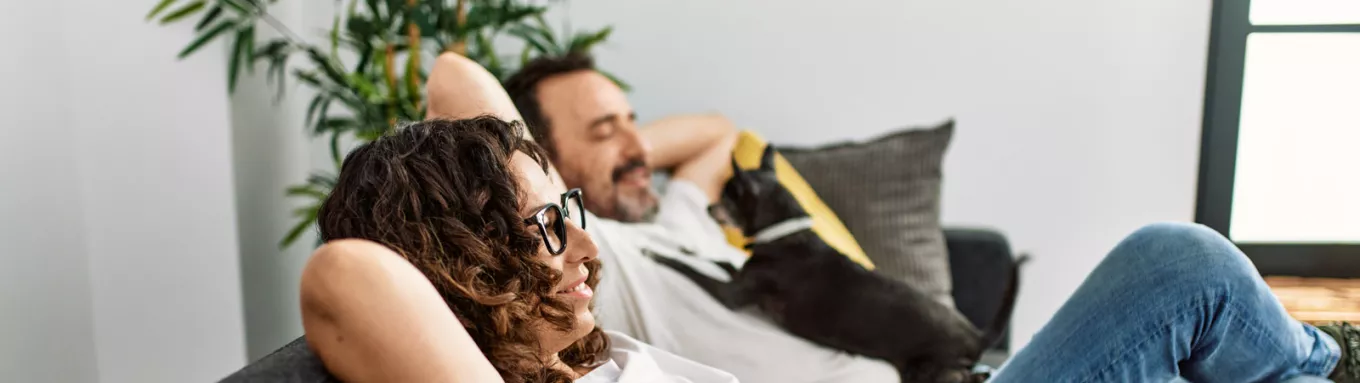 Man and woman relaxing on sofa with a dog 