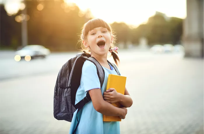 girl at school with backpack and books 