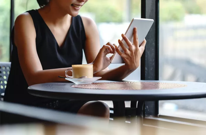 woman having a coffee on a tablet 