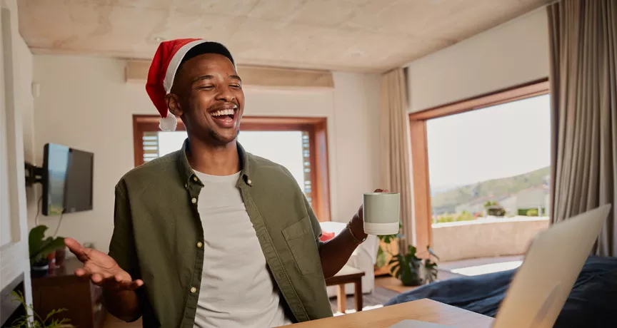 man sat at his desk with a Christmas hat on 