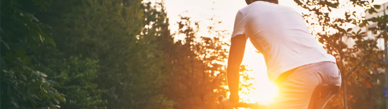 Man cycling into the sunset