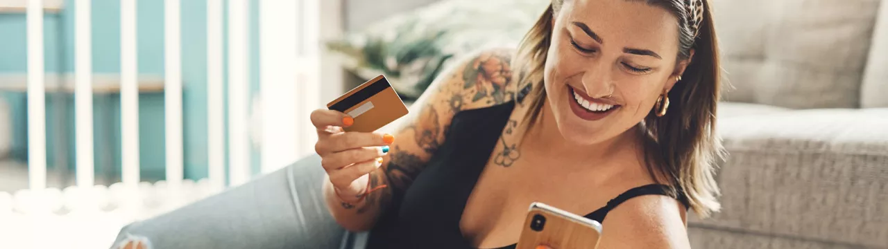 woman lying on the floor with her phone and bank card