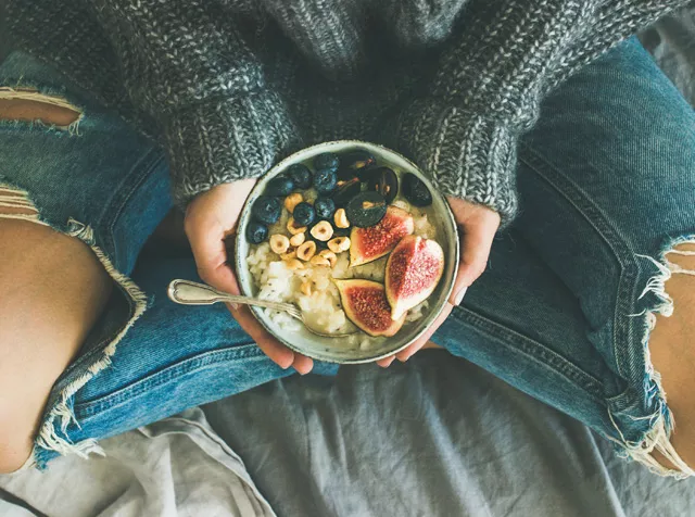 woman sitting with healthy bowl of fruit