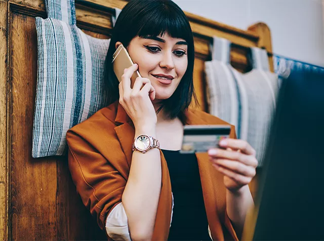 brunette on the phone and using her bank card