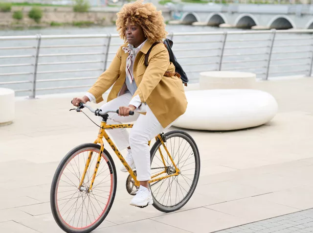 black woman cycling along a river