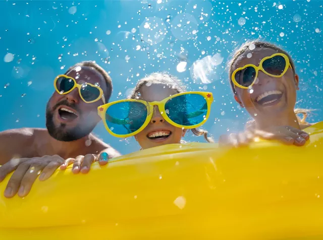 family on holiday riding an inflatable