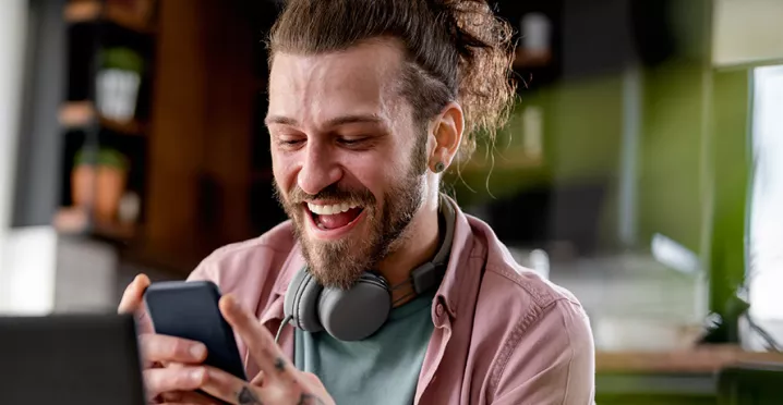 Man on phone at desk looking happy