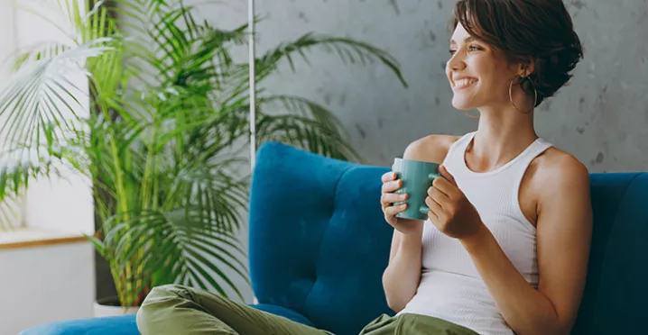 Woman relaxing on her sofa with a drink