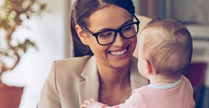 Woman holding a baby while working