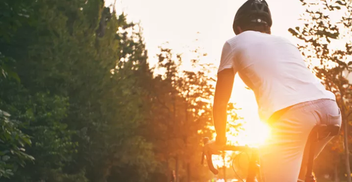 Man cycling into the sunset