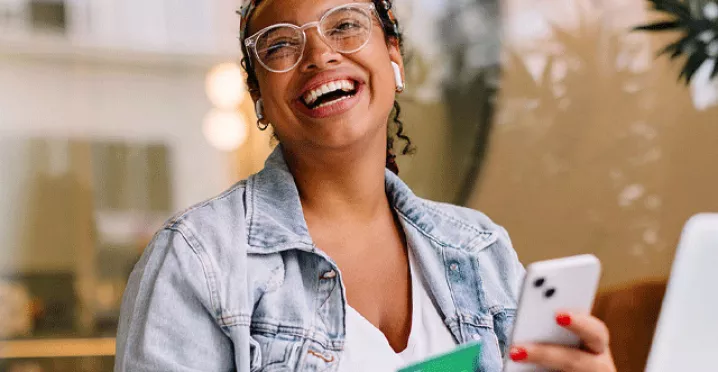 Lady holding a phone and a Pluxee Visa Card