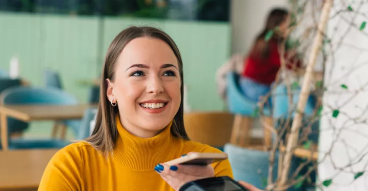 woman paying with phone is cafe