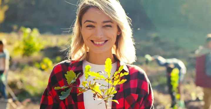 woman in a field holding a plant