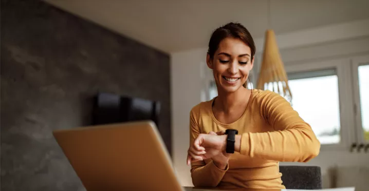 woman at desk checking her watch
