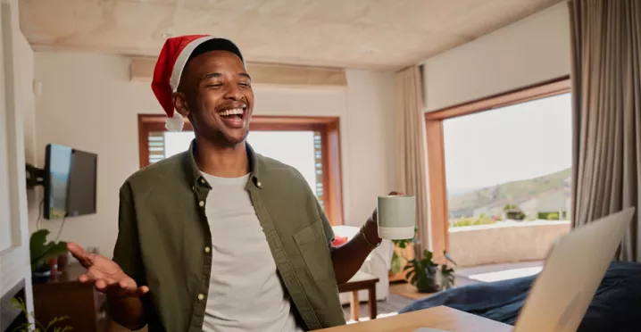 man sat at his desk with a Christmas hat on