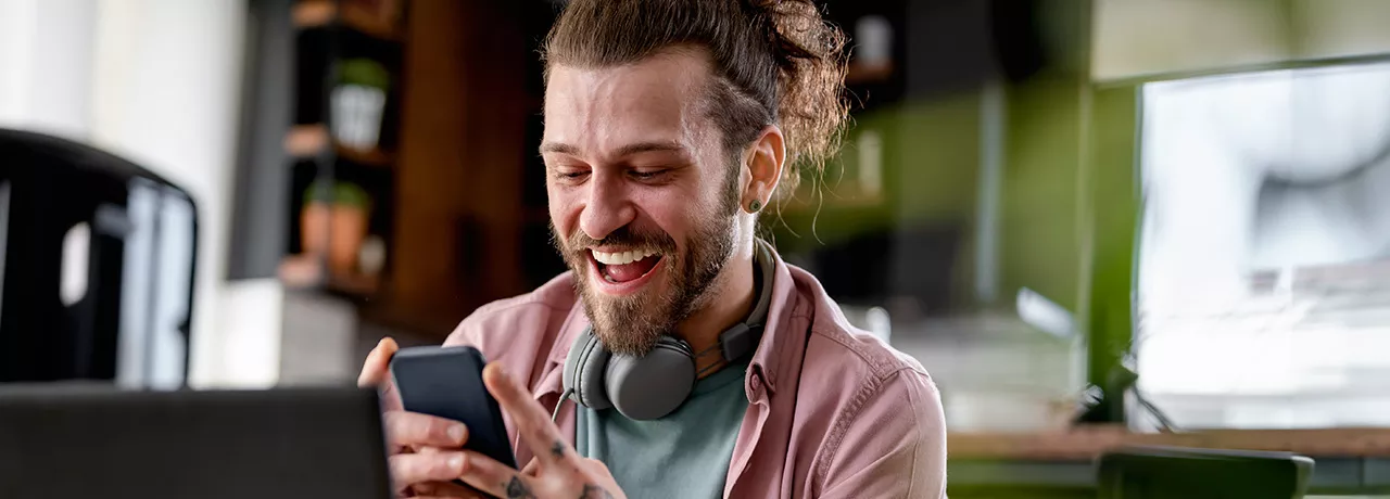 Man on phone at desk looking happy