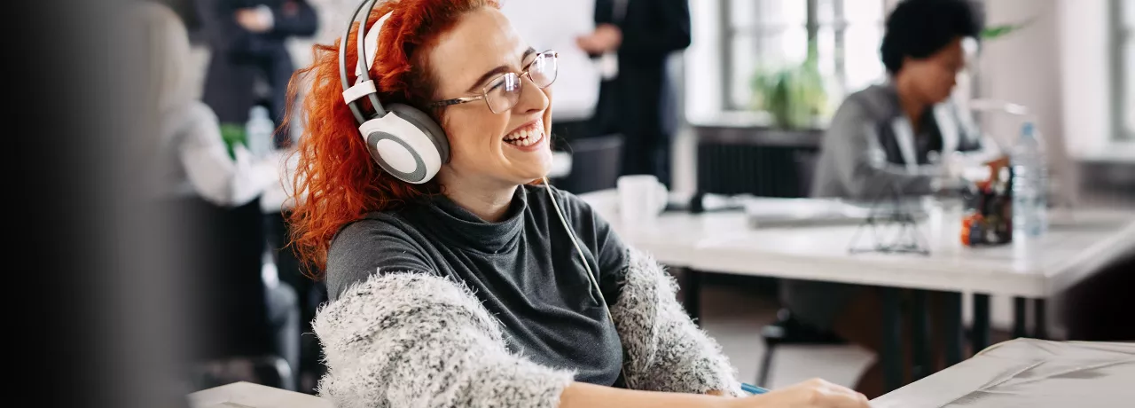 woman sat at desk with headphones
