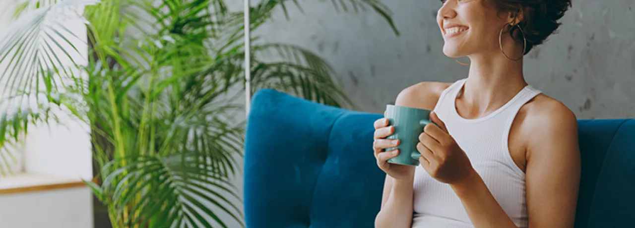 Woman relaxing on her sofa with a drink