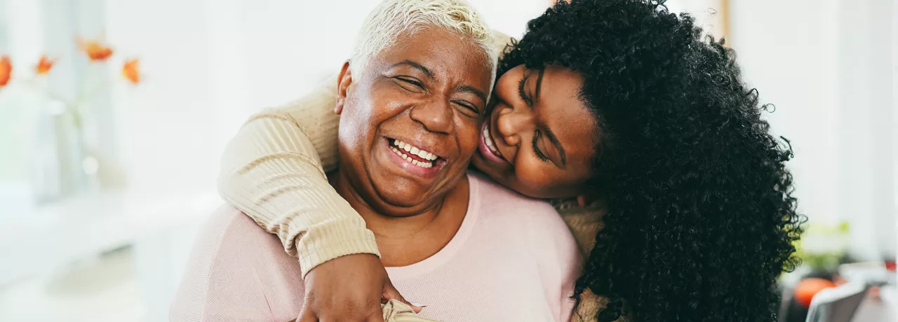 Old and young black women hugging and smiling