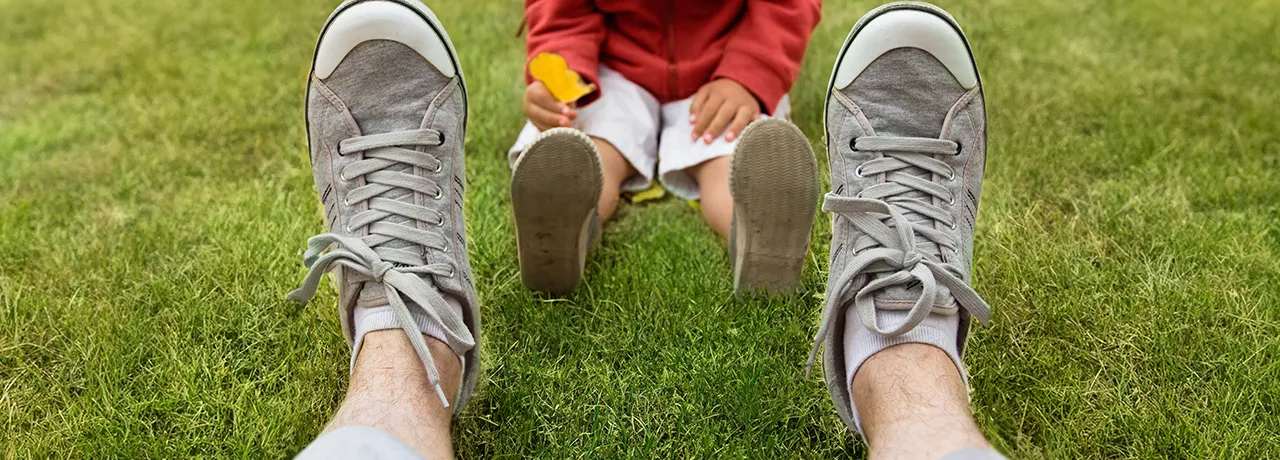 dad sitting in the grass with his child