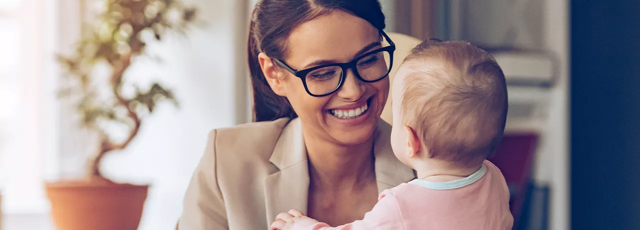 Woman holding a baby while working