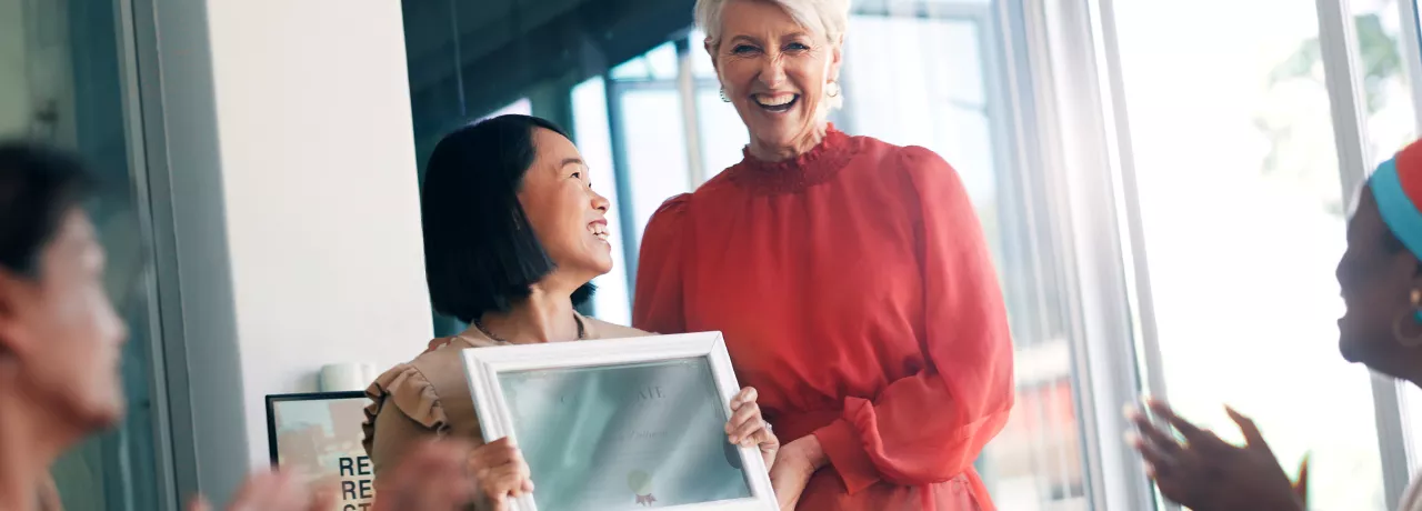 Woman giving a certificate to her colleague