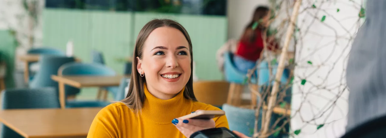 woman paying with phone is cafe