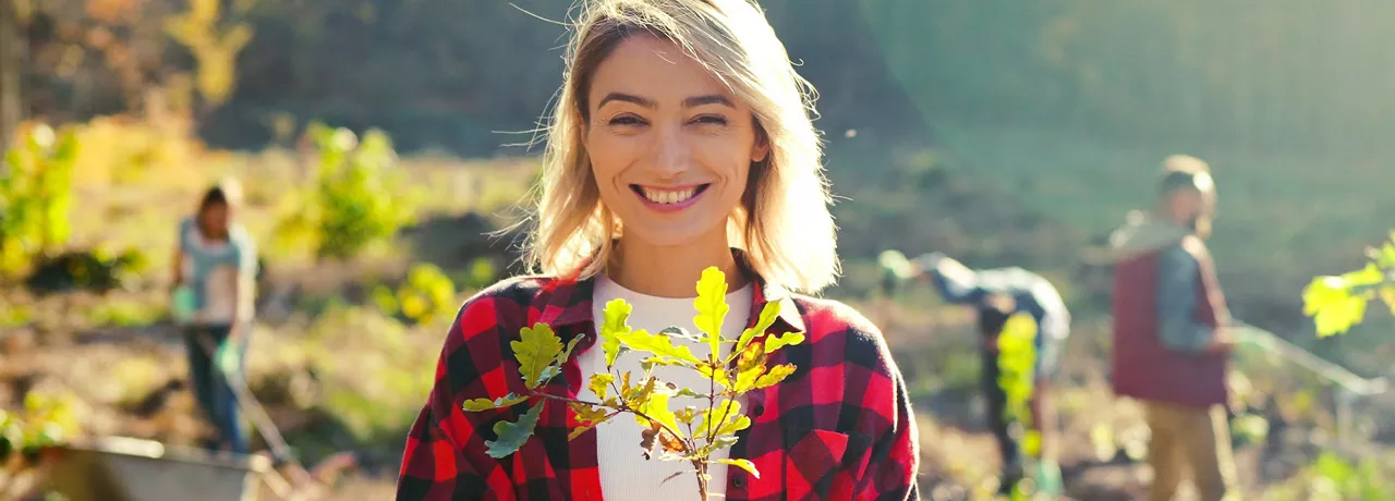 woman in a field holding a plant