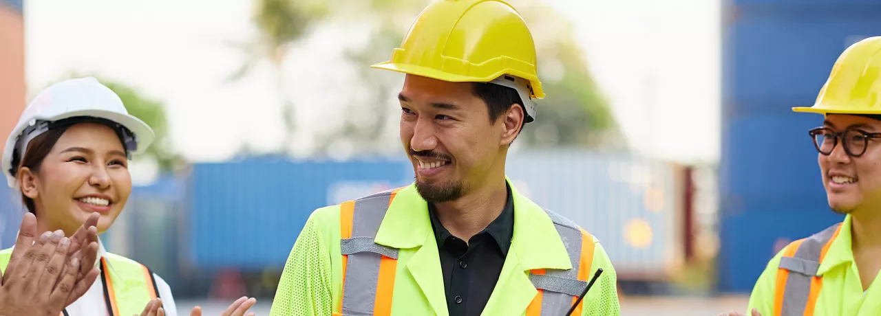group of people on a construction site clapping their collgeaue