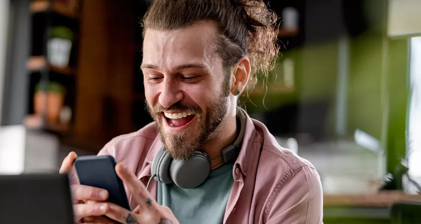 Man on phone at desk looking happy