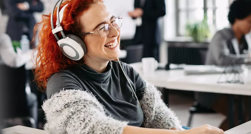 woman sat at desk with headphones