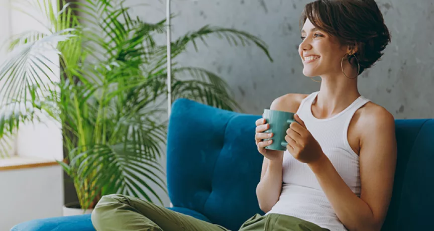 Woman relaxing on her sofa with a drink