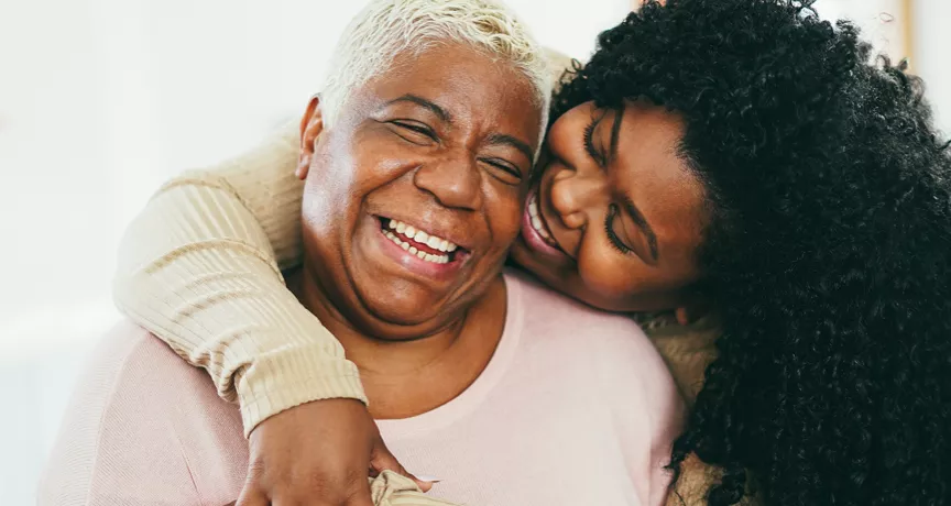 Old and young black women hugging and smiling