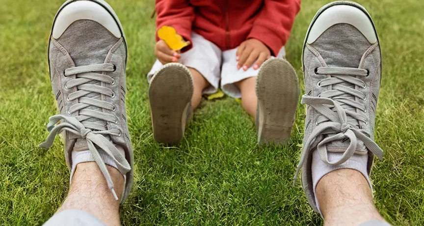 dad sitting in the grass with his child