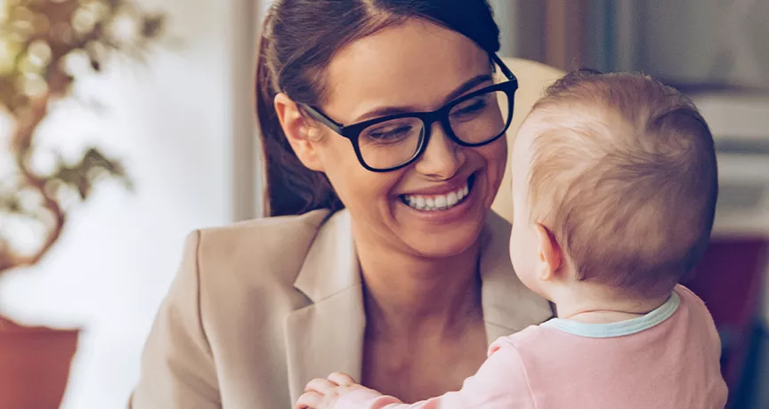 Woman holding a baby while working