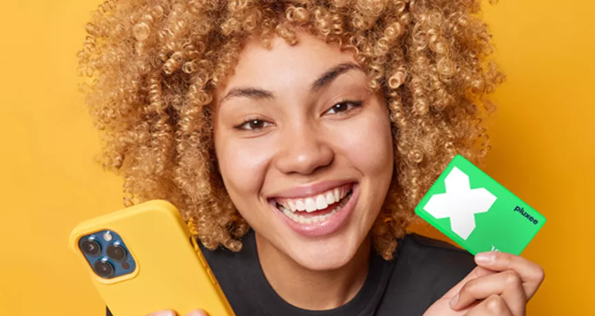 lady smiling and holding her Pluxee Card