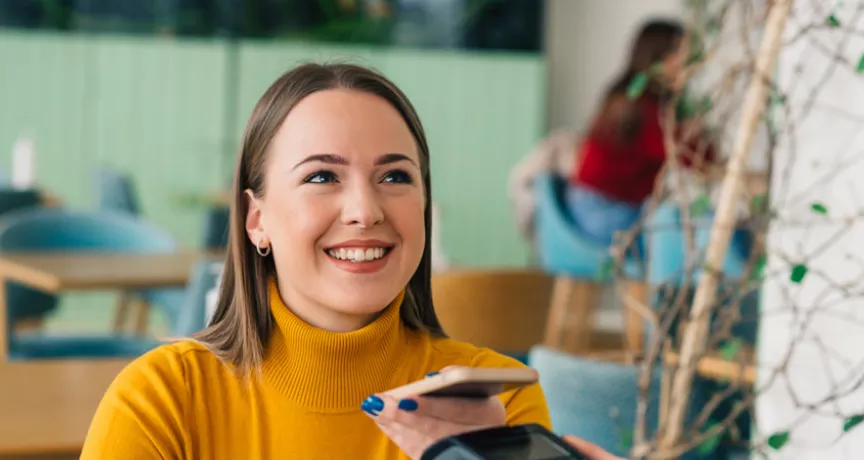woman paying with phone is cafe