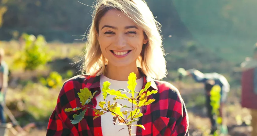 woman in a field holding a plant