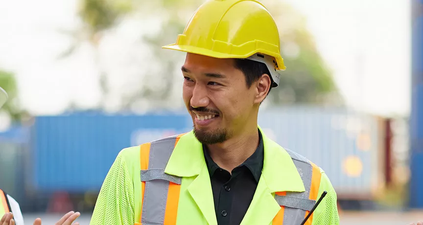 group of people on a construction site clapping their collgeaue