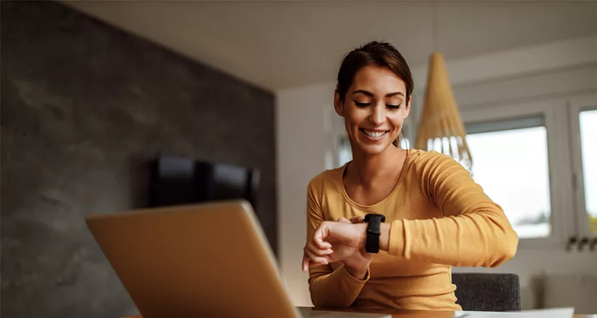 woman at desk checking her watch