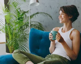 Woman relaxing on her sofa with a drink