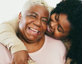 Old and young black women hugging and smiling