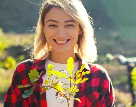 woman in a field holding a plant