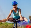 woman cycling through a meadow with he legs swinging out